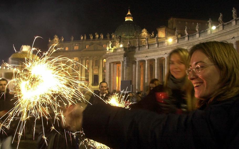 People hold firecrackers in St. Peter's square at the Vatican at midnight on a past New Year's Eve. (AP Photo/Pier Paolo Cito)