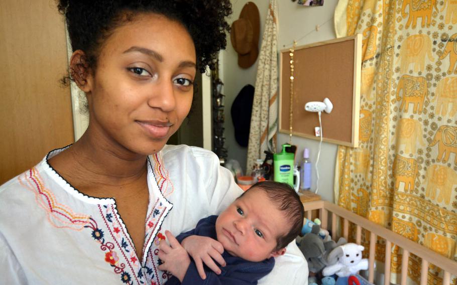 Kayla Germany, 18, holds her newborn son, Dimitri, at her home at Yokosuka Naval Base, Japan. Kayla's father, a Navy chief petty officer, is applying for his new grandson to remain with them in Japan, but the outcome remains undecided.