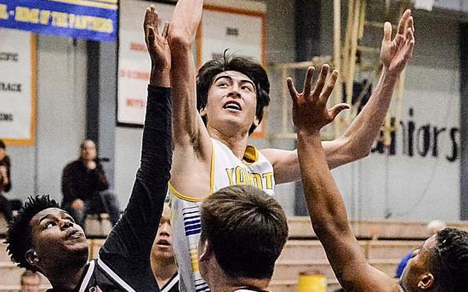 Yokota's Hunter Cort stands tall and shoots over Zama defenders Rafael Labrador, Joshua Atkinson and Ziaire Johnson during Friday's boys basketball game, won by the Panthers 84-49.