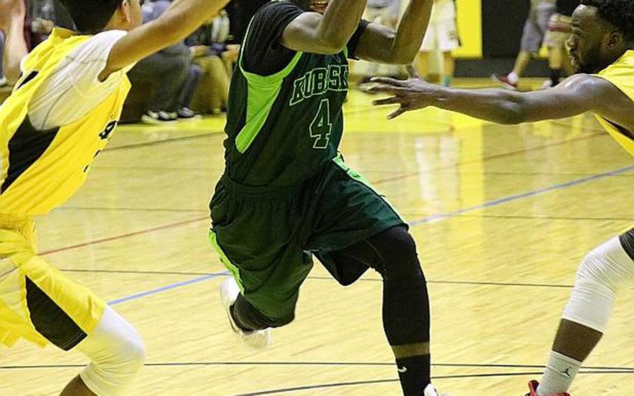 Kubasaki's Xavier Carmouche drives between two Kadena defenders during Friday's boys basketball game, won by the two-time defending Far East Division I Tournament champion Dragons 68-62, their first win over the Panthers in four tries this season.