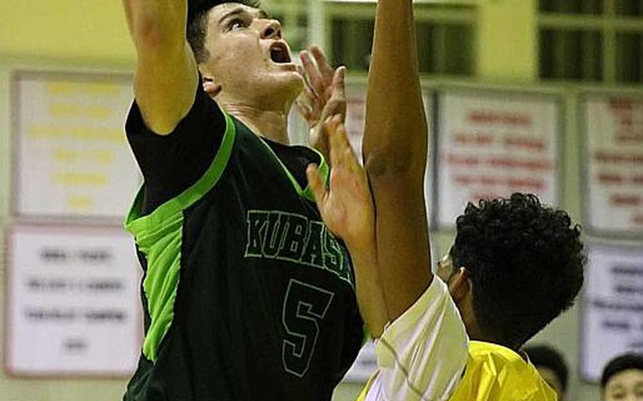 Kubasaki's Bobby Riegert goes up for a shot against Kadena's J.J. Daniels during Friday's boys basketball game, won by the two-time defending Far East Division I Tournament champion Dragons 68-62, their first win over the Panthers in four tries this season.