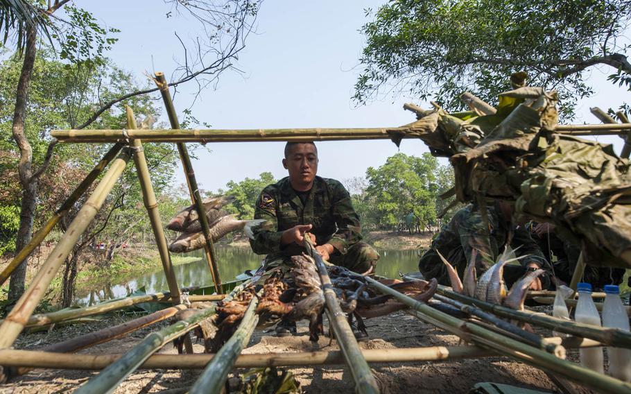 A Thai Marine prepares exotic delicacies during jungle-survival training as part of Cobra Gold drills underway in Thailand.