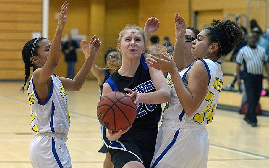 Hohenfels' Maddy Black drives through the Ansbach defense of Shermaine Nesbitt, left, and Kayla Stange in a game at the DODEA-Europe basketball finals in Wiesbaden, Thursday Feb. 23, 2017. Hohenfels won the Division III game 22-15.