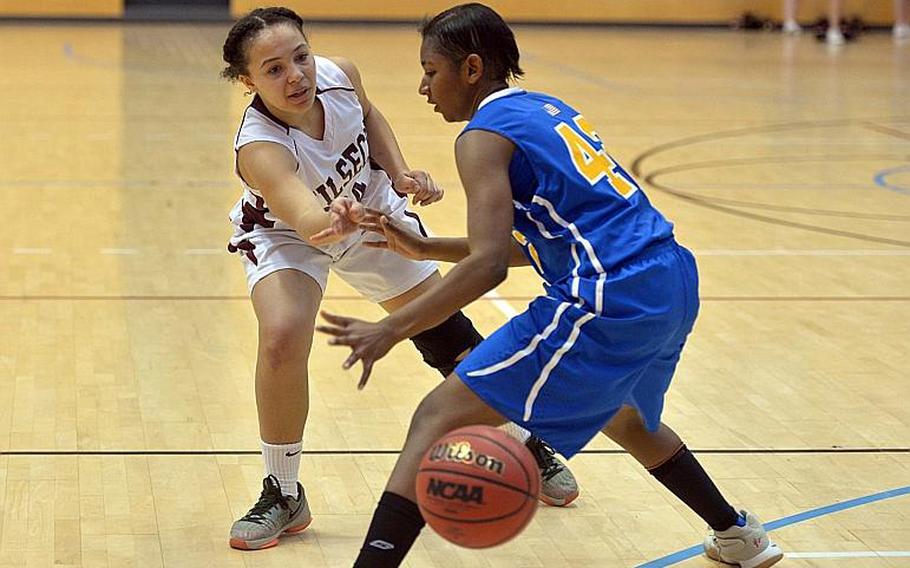 Vilseck's Michaela Lewis passes the ball past Wiesbaden defender Corban Jackson in a Division I game at the DODEA-Europe basketball finals in Wiesbaden, Thursday Feb. 23, 2017. Wiesbaden won the game 27-17