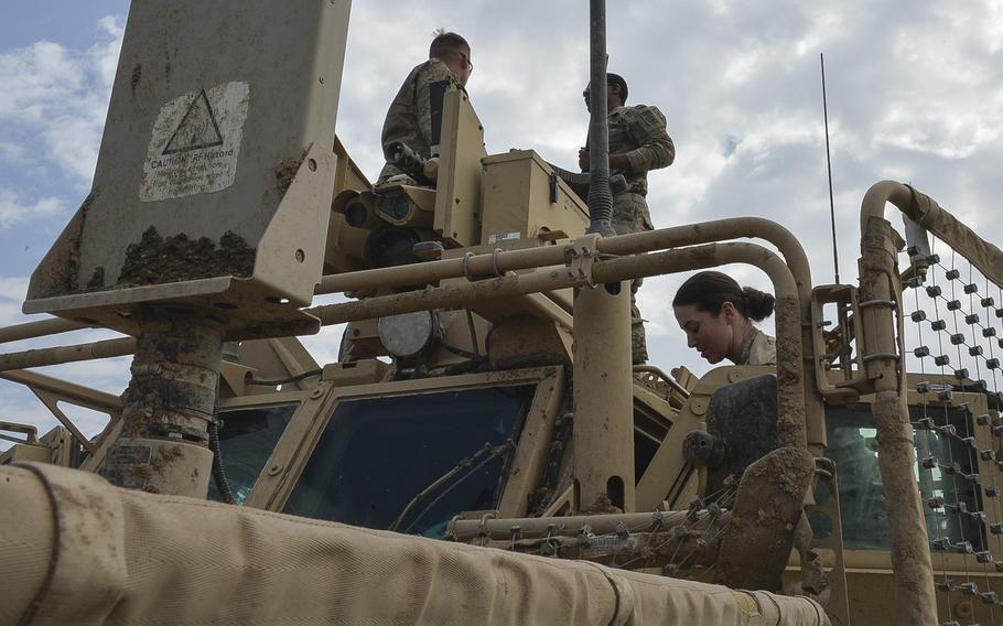 Pfc. Alexandria Campbell helps Sgt. Brandon Bush and Pfc. Shayne Jensen install a .50-caliber machine gun on the Common Remotely Operated Weapon Station atop a mine-resistant vehicle on Qayara Airfield West, Friday, March 17, 2017. Since March 2016, the military has been integrating women into many combat roles previously closed to women.