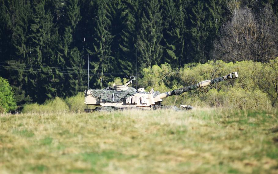 An Army M109 Paladin Howitzer, partially hidden behind a hill, prepares to fire during a combined-arms live-fire exercise, Monday, April 10, 2017, at the Grafenwoehr Training Area, Germany.