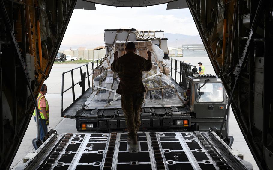 Senior Airman Ryan Berry, 26, of Bedford, Texas, right, loads cargo onto a C-130J at Bagram Air Field, Afghanistan, May 4, 2017.