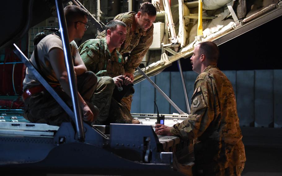 From left, Senior Airman Michael Bates, 22, of Athens, Ala., Senior Airman Ryan Berry, 26, of Bedford, Texas, and Capt. Brennan Wolford, 29, of Thornville, Ohio, confer with Master Sgt. John Beal, superintendent of the 774th Expeditionary Airlift Squadron, at Bagram Air Field, May 4, 2017.