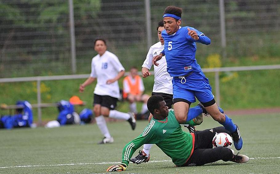 Hohenfels keeper Frantz Moise makes a sliding stop against Brussels' Paul Hubbard, but his efforts were not enough as the Tigers fell to the Brigands 7-0 in Division III action at the DODEA-Europe soccer championships in Landstuhl, Germany.