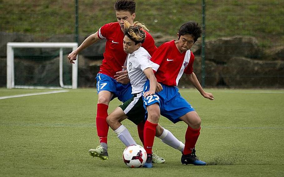 SHAPE's Arda Oktar tries to get between International School of Brussels' Keiko Petzold, left, and Koki Otsu during the DODEA-Europe soccer tournament in Reichenbach, Germany, on Thursday, May 18, 2017. SHAPE and ISB tied the Division I match 1-1.

MICHAEL B. KELLER/STARS AND STRIPES