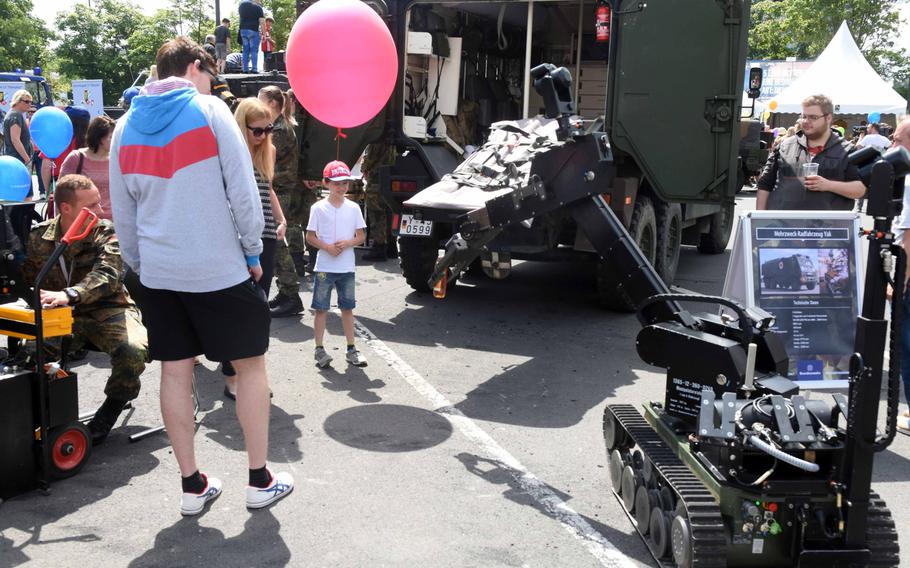 A German army robot hands a drink to a child at the Day of the German Army event in Weiden, Germany, Saturday, June 10, 2017.