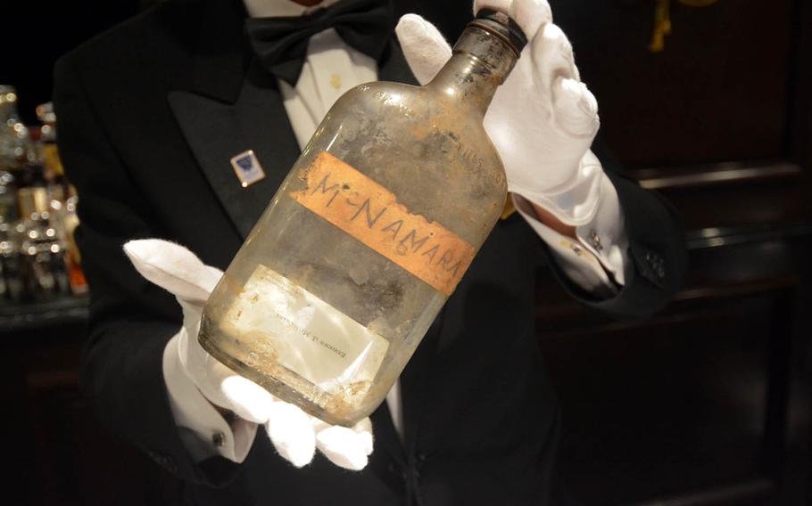 Keisuke Ohta, manager of Bar Sea Guardian II at the Hotel New Grand in Yokohama, Japan, holds the bottle found by construction workers during the hotel's recent renovation. Inside the bottle is the business card for Lt. Col. Eugene J. McNamara, a guest during the post-World War II occupation. The hotel would like to find McNamara's family.