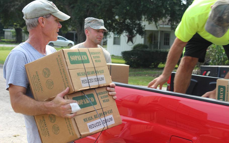 Army veteran Doug Robinson and members of the First Baptist Church in China, Texas, help deliver emergency ration meals to a citizen outside of his church on Sept. 3, 2017.