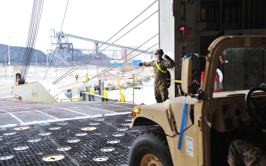 Spc. Loren Laws, a motor transport operator from the 227th Quartermaster Company, 129th Combat Sustainment Support Battalion, 101st Airborne Division Sustainment Brigade, directs vehicles off a cargo ship in Gdansk, Poland, March 28, 2017.