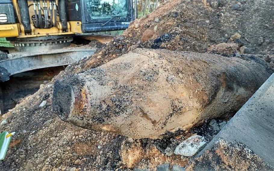 A WWII-era, unexploded bomb sticks out of the dirt at a construction site for a new school near the U.S. Army's Grafenwoehr Training Area on Wednesday. German authorities defused it and U.S. soldiers later detonated the 1,000-pound bomb.