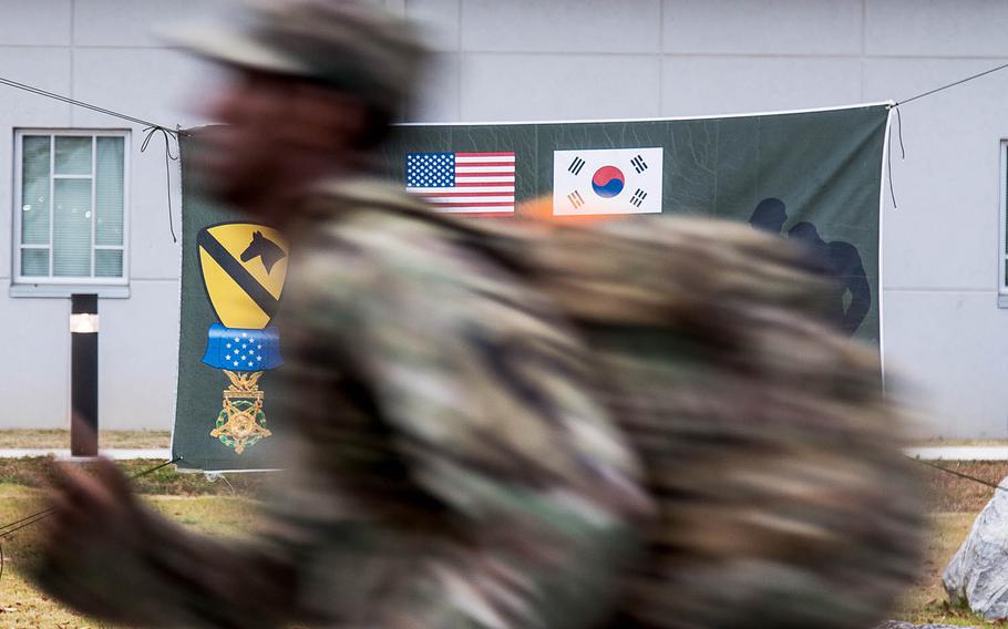 A soldier marches by a sign for the 2017 Kapaun Memorial Ruck March at Camp Humphreys, South Korea, Thursday, Nov. 2, 2017.
