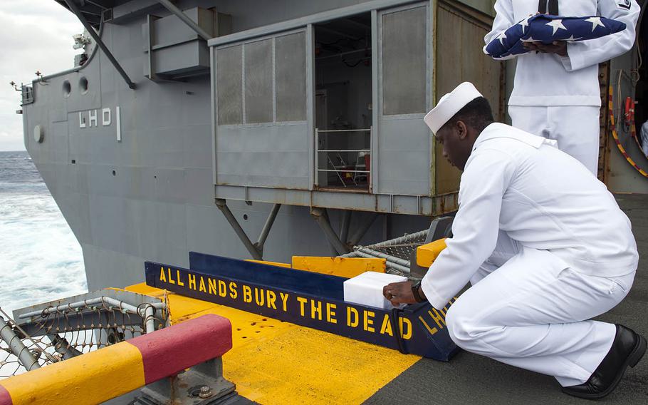 Petty Officer 3rd Class Andre Parrish of the amphibious assault ship USS Wasp prepares to bury the cremains of Navy veteran Conrad Strub in the Atlantic Ocean, Wednesday, Nov. 29, 2017.