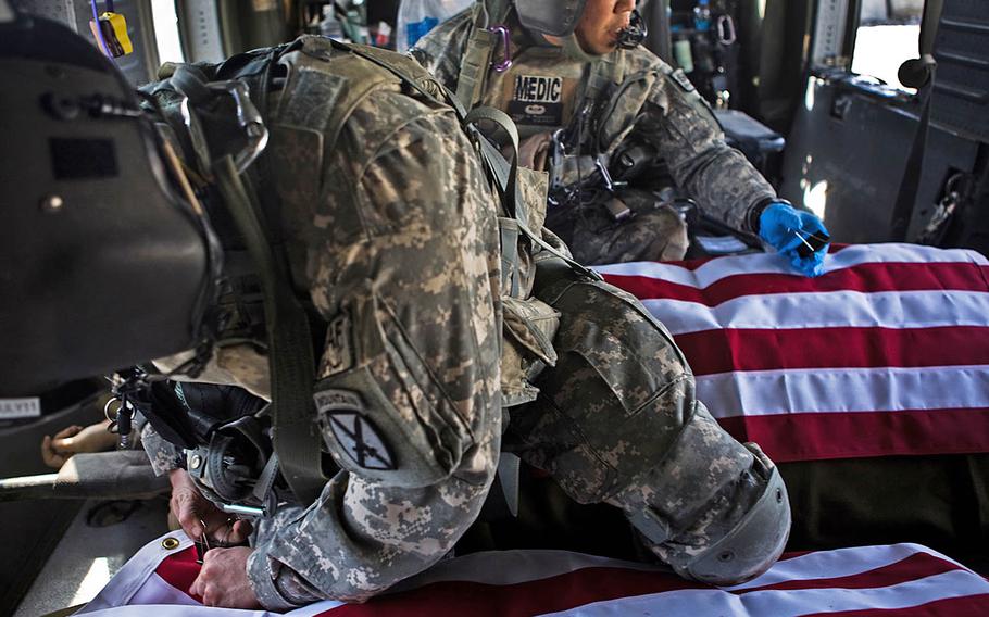 Medics with the 10th Mountain Division’s Company C, 3rd General Support Aviation Battalion, 10th Aviation Regiment, work to cover the bodies of two U.S. soldiers killed in eastern Afgahnistan in 2011. Six men from the medevac unit were followed home from the mission in the documentary "Trauma."