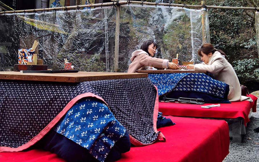 The outdoor dining area at Kamado, near Marine Corps Air Station Iwakuni, Japan, is filled with brightly colored tables at the base of a waterfall.