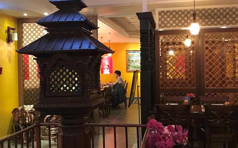The decor at Om in Seoul, South Korea, features lattice wood carvings, imported wall hangings, elephant statues and other exotic decorations.