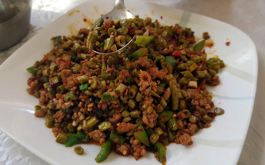 Fried pickled bean with mincemeat is a stir-fried mixture of ground pork and chopped, marinated Chinese snake beans from Hunan Cuisine in Honolulu.