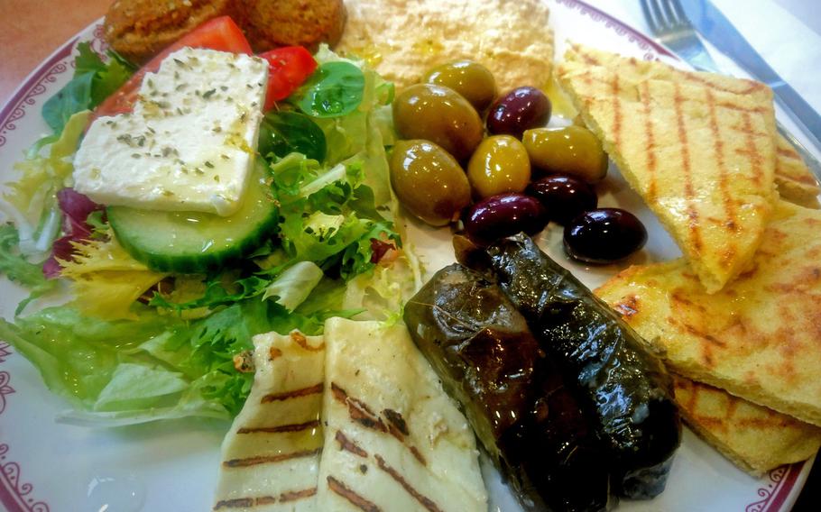 A Meze plate with grilled halloumi, mixed olives, hummus, falafels, stuffed vine leaves and salad with feta cheese at Cafe Kottani in Bury St Edmunds, England. There are four Meze plates for either 7.95 or 8.95 pounds ($11.25 to $12.66).