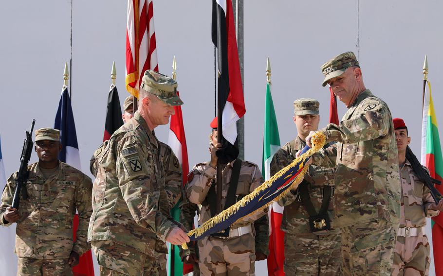 Maj. Gen. Walter Piatt, right, commander of Combined Joint Forces Land Component Command, and his senior enlisted advisor, Command Sgt. Maj. Samuel Roark,roll up the CJFLCC flag during a deactivation ceremony in Baghdad, Iraq, April 30, 2018.