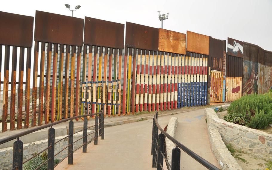 An upside-down American flag — a national distress signal — is painted on the south side of the U.S.-Mexico border wall near San Diego as a symbol for the plight of deported veterans.