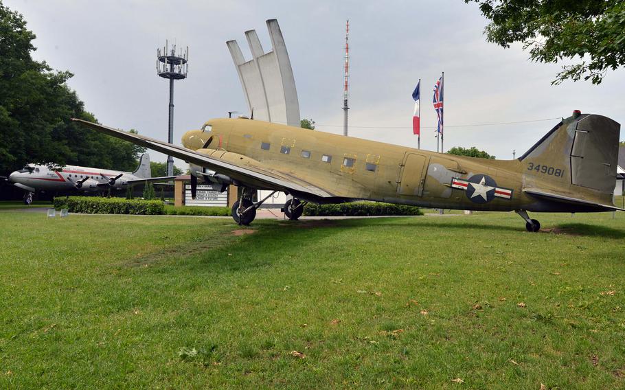 A Douglas C-47 ''Goonie Bird'' stands in the foreground at the Berlin Airlift Memorial on the edge of Frankfurt, Germany's international airport. The three fingers of the monument represent the three air corridors from West Germany to West Berlin. In the background is a Douglas C-54 Skymaster.