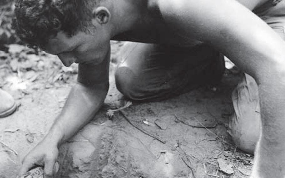 In January 1967, a "tunnel rat" from the 25th Infantry Division prepares to check a Viet Cong tunnel with his 1911 pistol and a flashlight.
