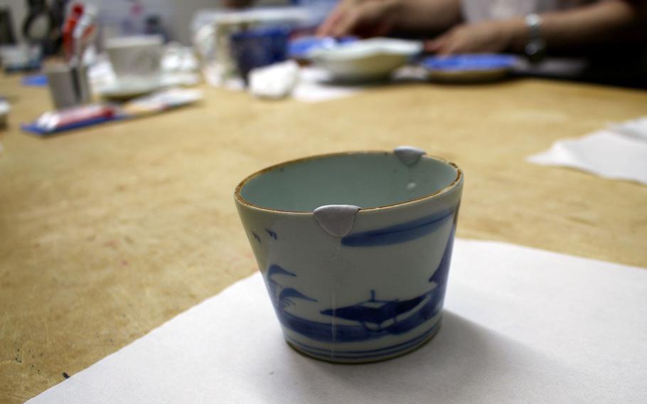At the kintsugi class at Kuge Crafts, students reattach broken pottery pieces and use clay to fill gaps in the ceramic. In this photo, the teacup is still in the process of being primed for the final step of having the repairs painted in gold lacquer.