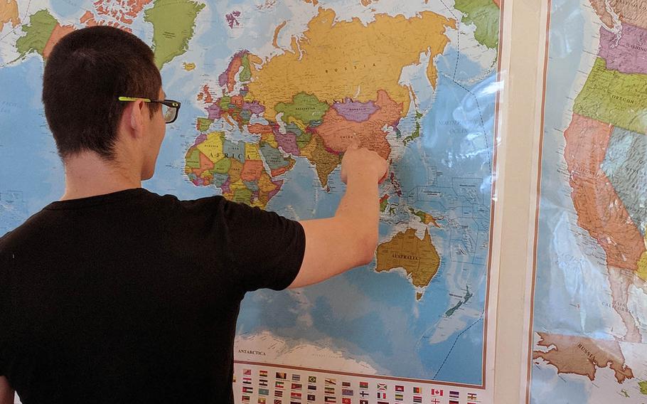 Luo Shu, a Chinese-born recruit into the U.S. Army, points to a map of the world hanging in his sparse apartment. Luo was arrested for deportation after his military contract expired because of an administration error, but the Army recently reinstated him.