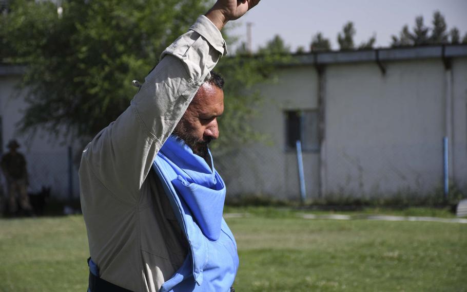 Sahd Qasem, an Afghan de-miner, holds up his hand and yells "Mine!" three times to indicate confirmation of explosive ordnance during training at the Mine Detection Center in Kabul, Afghanistan.