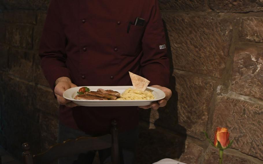 Skendo Shala, the chef of Ristorante Cardinale in Kaiserslautern, Germany, holds a plate of saltimbocca alla Romana, made of veal lined with prosciutto.