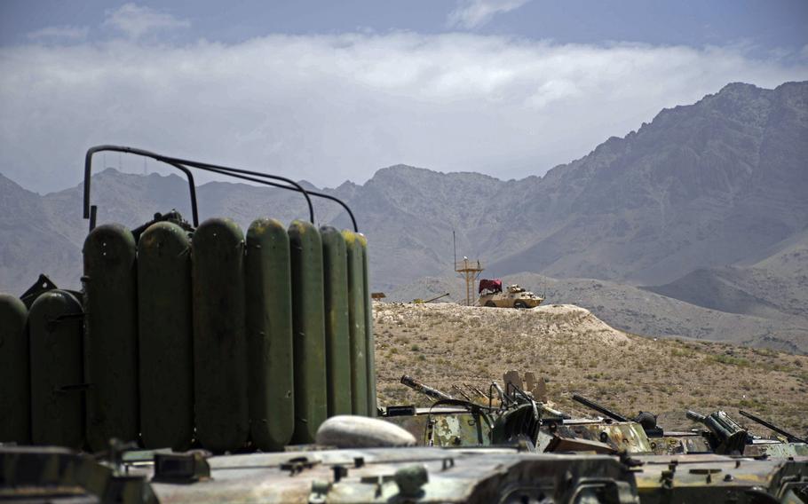 An Afghan mobile strike force vehicle stands watch on a ridge overlooking a lot full of obsolete Soviet-made tanks at an army base on the eastern outskirts of Kabul on Saturday, June 23, 2018.