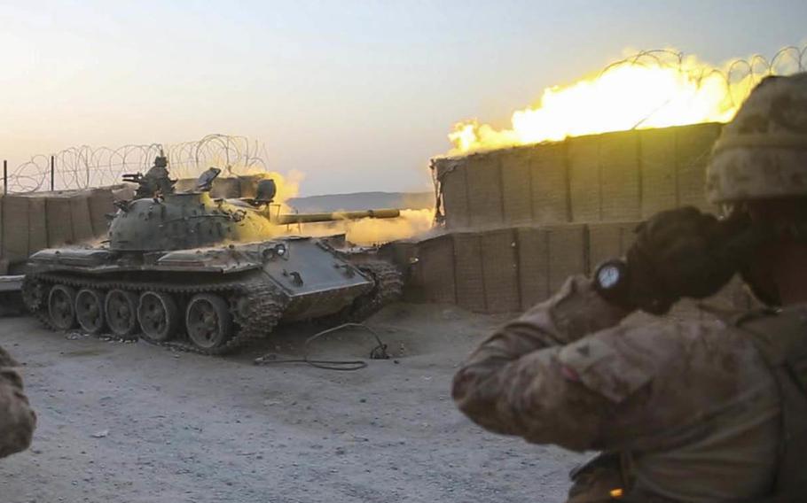 U.S. Marines with Task Force Southwest watch as an Afghan T-55 fires at an enemy position during an advisory mission at Camp Nolay in Sangin district, Helmand province, Wednesday, Aug. 8, 2018.