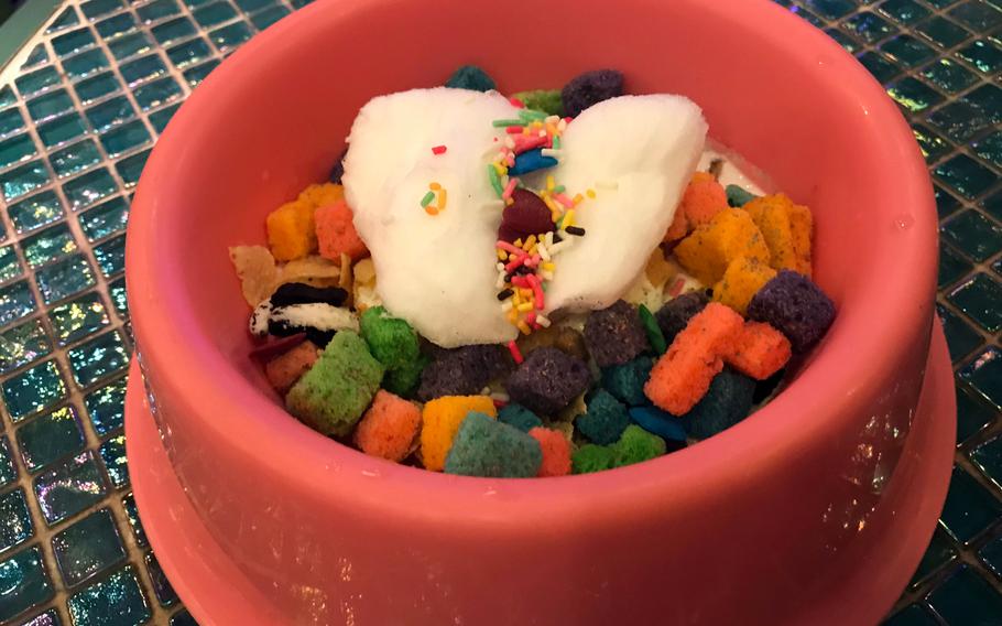 Pink Cat Food is one of the many unique menu options at Kawaii Monster Cafe, and features colorful cereal topped with vanilla ice cream and cotton candy presented in a cat food bowl.