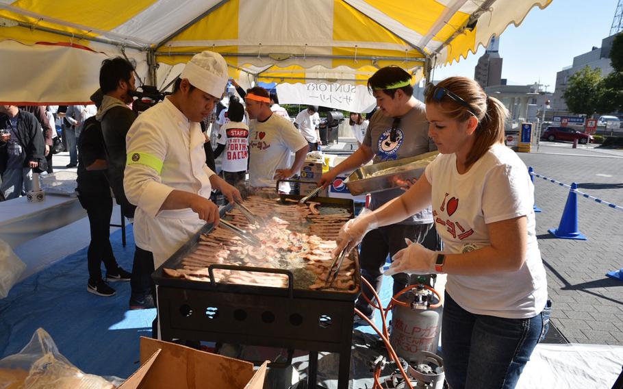 Festival staff fry some of the 40,000 strips of bacon given away at the Japan Bacon Festival in Kofu, Japan, on Nov. 3, 2017.