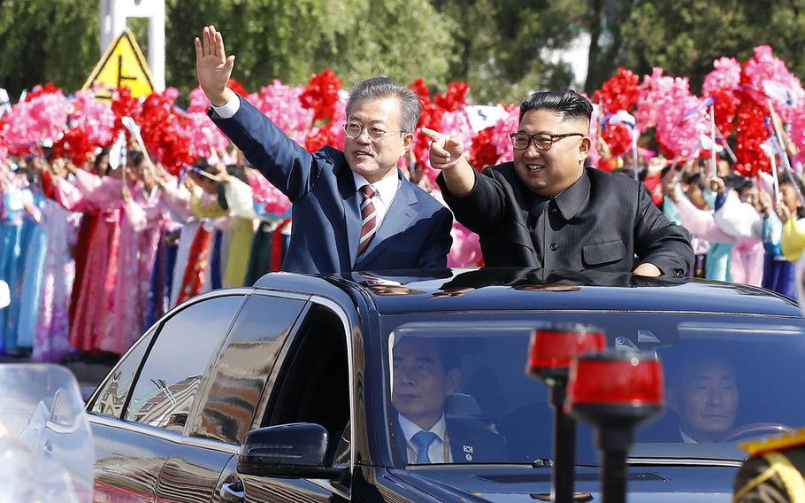 A vehicle carrying South Korean President Moon Jae-in, left, and North Korean leader Kim Jong Un makes its way through Pyongyang, North Korea, Tuesday, Sept. 18, 2018.