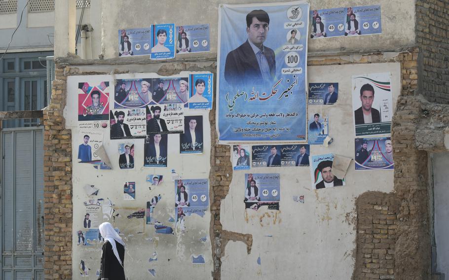 A man walks past campaign posters in Kandahar, Afghanistan, on Saturday, Oct. 27, 2018, the day the province voted in delayed parliamentary elections. 

