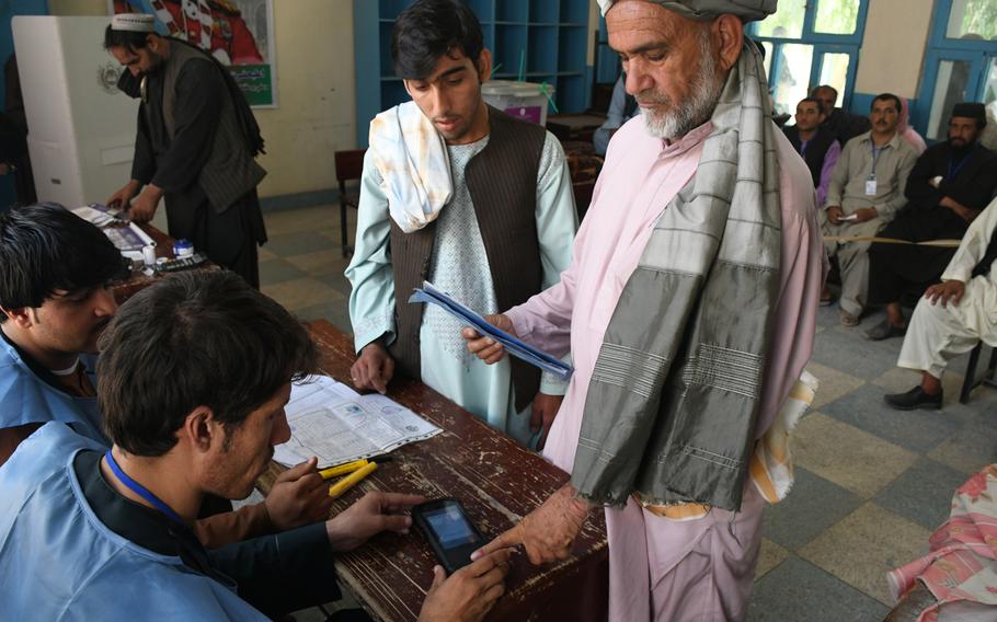 A man is identified with a biometric machine at a polling center in Kandahar, Afghanistan, on Saturday, Oct. 27, 2018, before voting in a parliamentary election.

