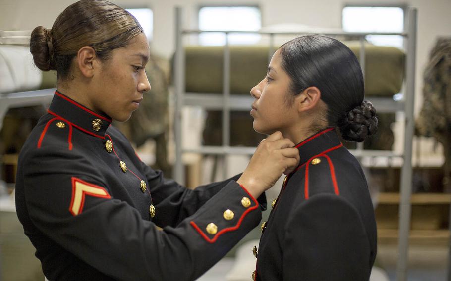 Pfc. Kathy Espinoza, of New York, N.Y., inspects the uniform of Pvt. Arella Aleman, of Dallas, at Marine Corps Recruit Depot Parris Island, S.C., Nov. 9, 2018.