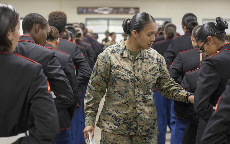 Sgt. Cristal Abregomedina, a warehouse clerk with Headquarters and Service Battalion, examines the uniforms of Marines from November Company, 4th Recruit Training Battalion at Marine Corps Recruit Depot Parris Island, S.C., Nov. 9, 2018.