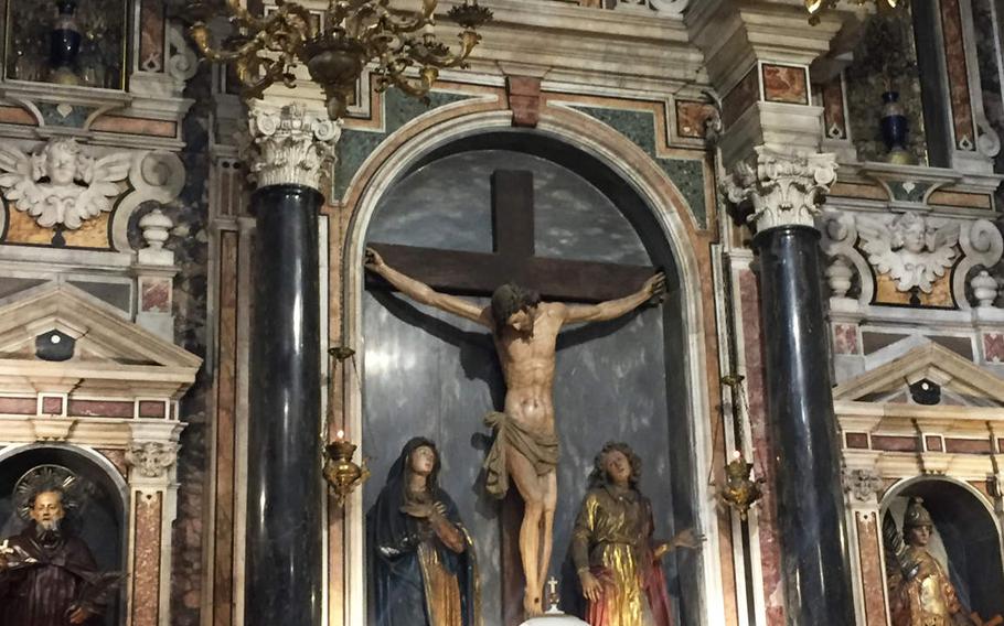 A crucifix is enshrined in an ornate wall at the Church of Gesu Nuovo in Naples, Italy.