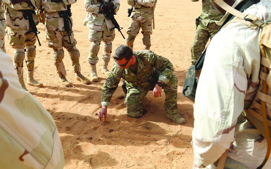 A soldier with the 3rd Special Forces Group uses rock drills to explain small unit tactics to Senegalese soldiers during  a training exercise earlier this year in Niger. Since the 2017 ambush the killed four U.S. soldiers in the country, the U.S. military  has struggled to reach consensus on which leaders should be blamed for poor  mission planning.