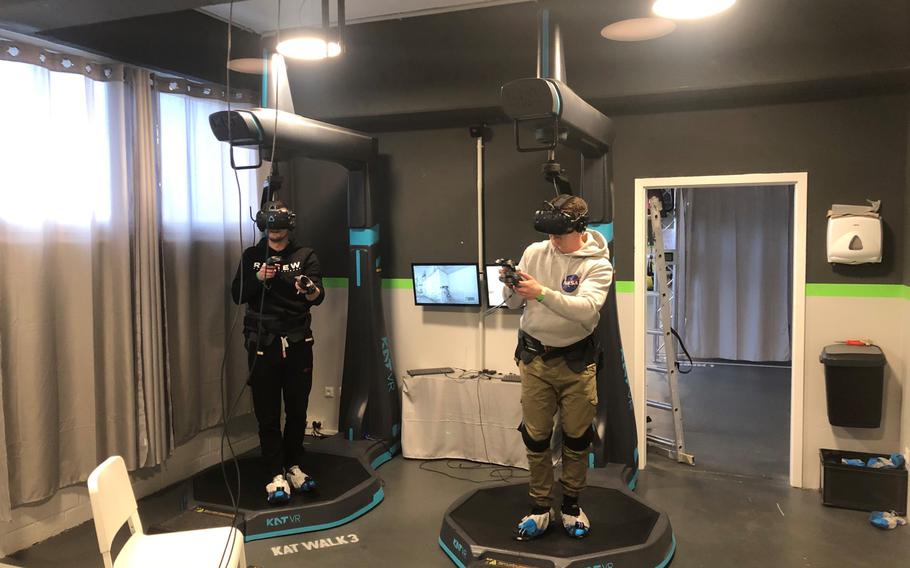 Customers at VArea in Mainz, Germany, use a Katwalk setup to fully immerse themselves in a virtual reality first person shooter game on Jan. 8. The gaming setup allows users to maneuver within the virtual reality environment without leaving the enclosed setup.