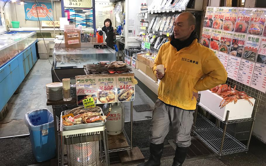 Shop attendants at Nijo Market in Sapporo stay warm thanks to small gas heaters in their stall.