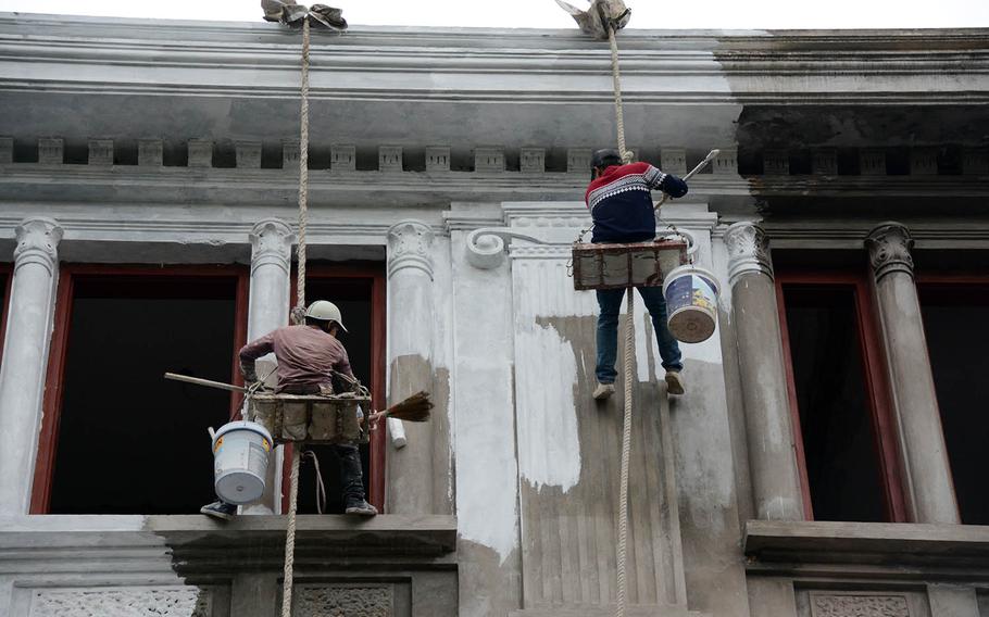 Workers paint a building near the summit press center in Hanoi, Vietnam, on Tuesday, Feb. 26, 2019.