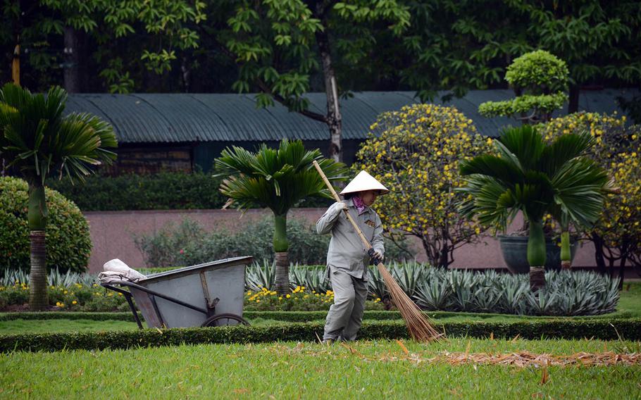 A woman sweeps the grounds near the Ho Chi Minh mausoleum in Hanoi, Vietnam, Tuesday, Feb. 26, 2019.