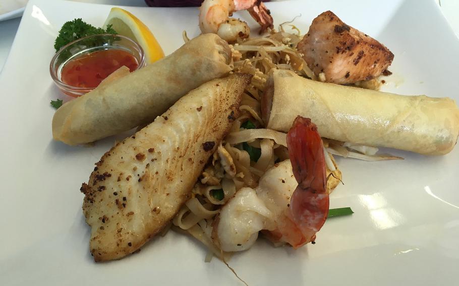The Asian plate at Fisch Schira in Kaiserslautern, Germany, includes a piece or perch, another of salmon, pad thai and two shrimp, with an option of two spring rolls added.
